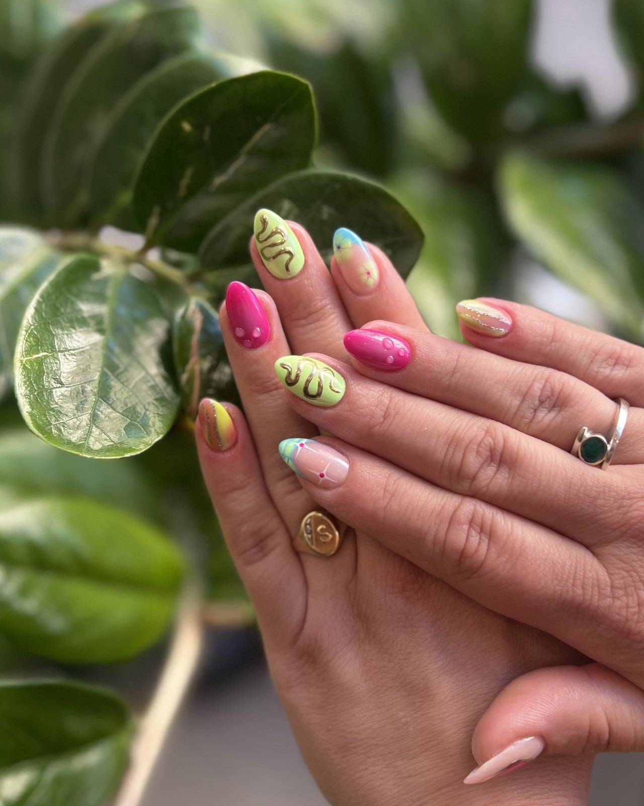 Ongles amande peints main : vert lime aux arabesques dorées, fuchsia en relief et dégradés pastel. Maison Jolis Nails, Aix-en-Provence